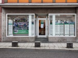 Der Eingang in der Ludwigstraße mit Schaufenstern und Aushängen