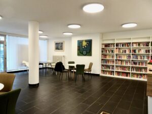 Aufenthaltsraum mit Sitzgruppen und Bücherregalen