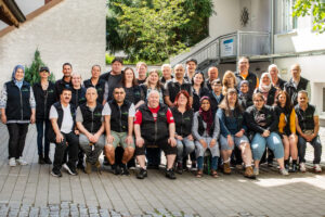 Rund dreißig Mitarbeiterinnen und Mitarbeiter des Kaufhauses im Freien