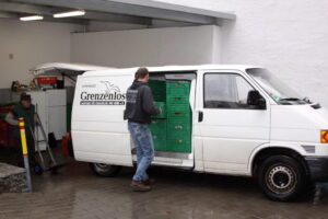 Ein Mitarbeiter belädt einen Kühltransporter mit Kisten
