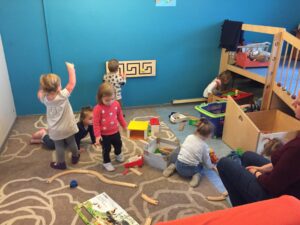 Kleinkinder spielen auf dem Teppich des Gruppenraums